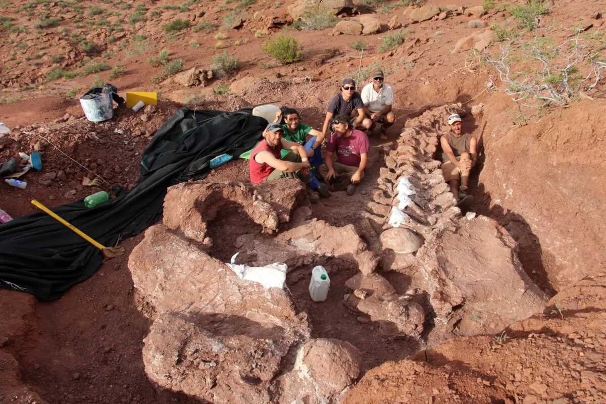 Palaeontologists pose for a picture next to an excavation of dinosaur bones and fossils that may have belonged to the largest dinosaur ever discovered, in Neuquen, Argentina, on Nov. 12, 2016. (CTyS-UNLaM/Handout via Reuters)
