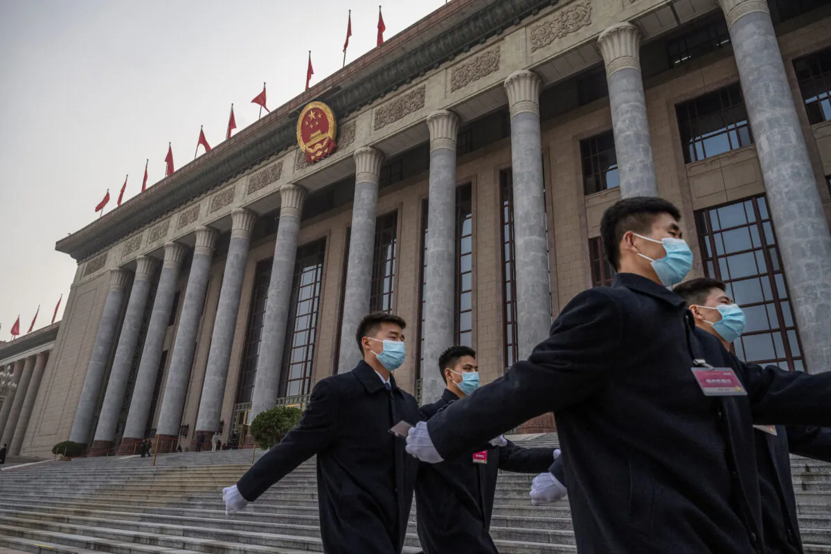 Chinese security wear protective masks as they march after the opening session of the Chinese People's Political Consultative Conference at the Great Hall of the People in Beijing, China, on March 4, 2021. (Kevin Frayer/Getty Images)