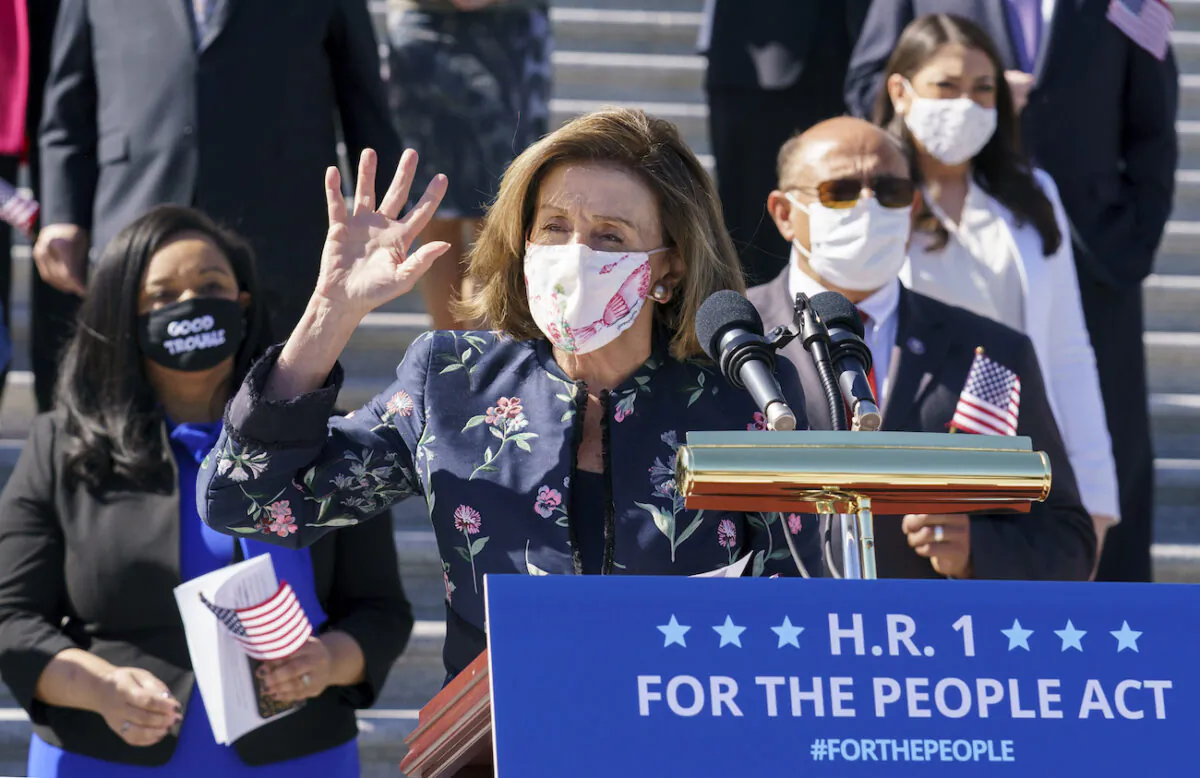 Speaker of the House Nancy Pelosi (D-Calif.)  and the Democratic Caucus gather to address reporters on H.R. 1, the For the People Act of 2021, at the Capitol in Washington, on March 3, 2021. (AP Photo/J. Scott Applewhite)