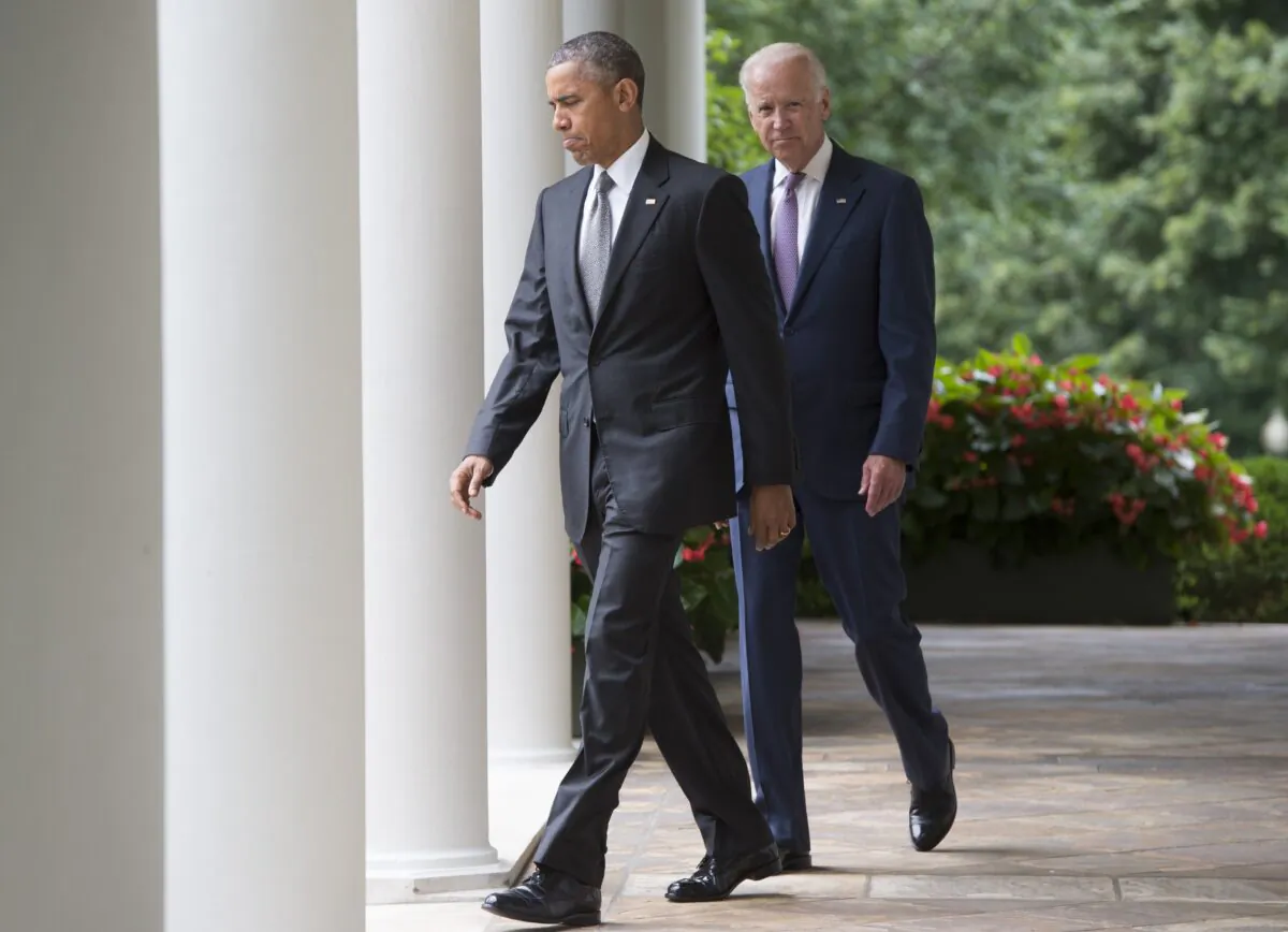 President Barack Obama walks with Vice President Joe Biden as they arrive to speak about the Supreme Court's ruling to uphold the subsidies that comprise the Affordable Care Act, known as Obamacare, in the Rose Garden of the White House in Washington on March 5, 2021. (Saul Loeb/AFP via Getty Images)