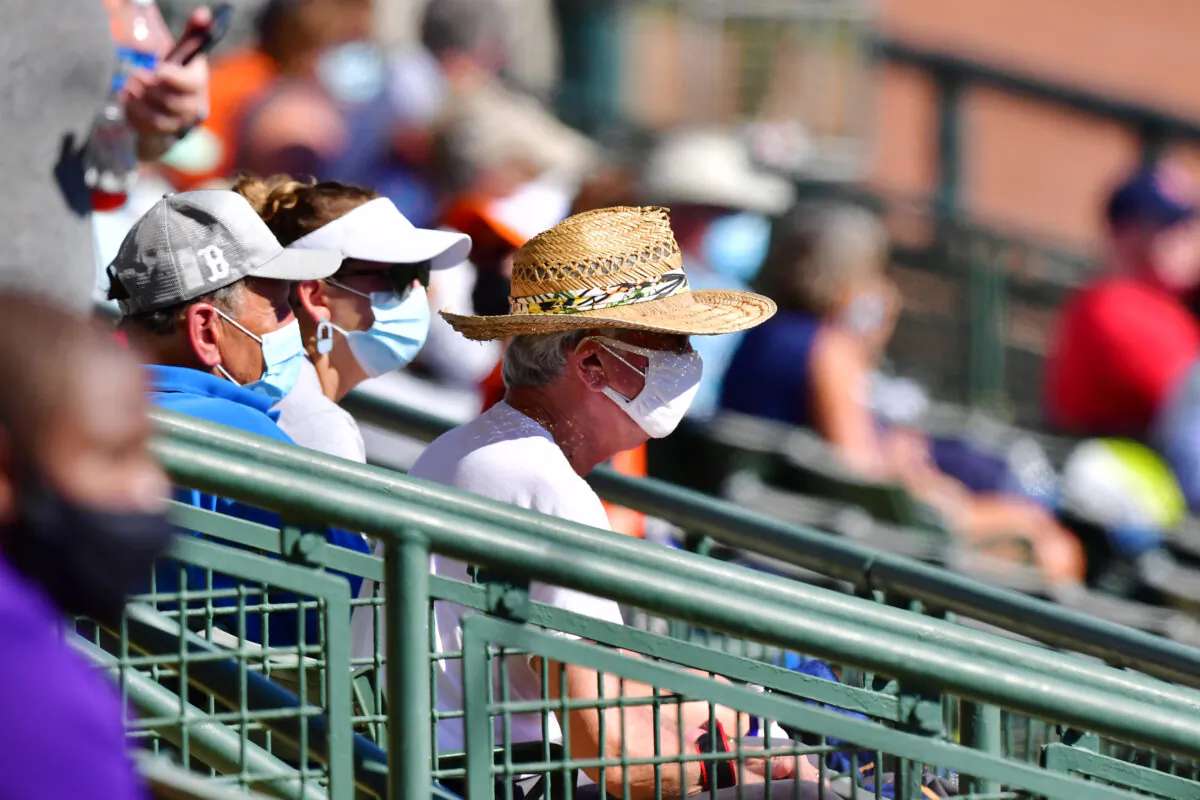 Masked fans look during a spring training game between the Baltimore Orioles and the Boston Red Sox at Ed Smith Stadium in Sarasota, Fla., on March 4, 2021. (Julio Aguilar/Getty Images)