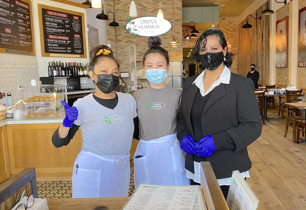 Restaurant floor manager Janet Henestroza (R) said she and her team are working hard to open for indoor dining at Oren’s Hummus in Mountain View, Calif., on March 4, 2021. (Nancy Han/NTD News)