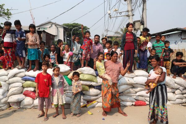 Local residents gather as the protesters march on a main road during a demonstration in Mandalay, Myanmar