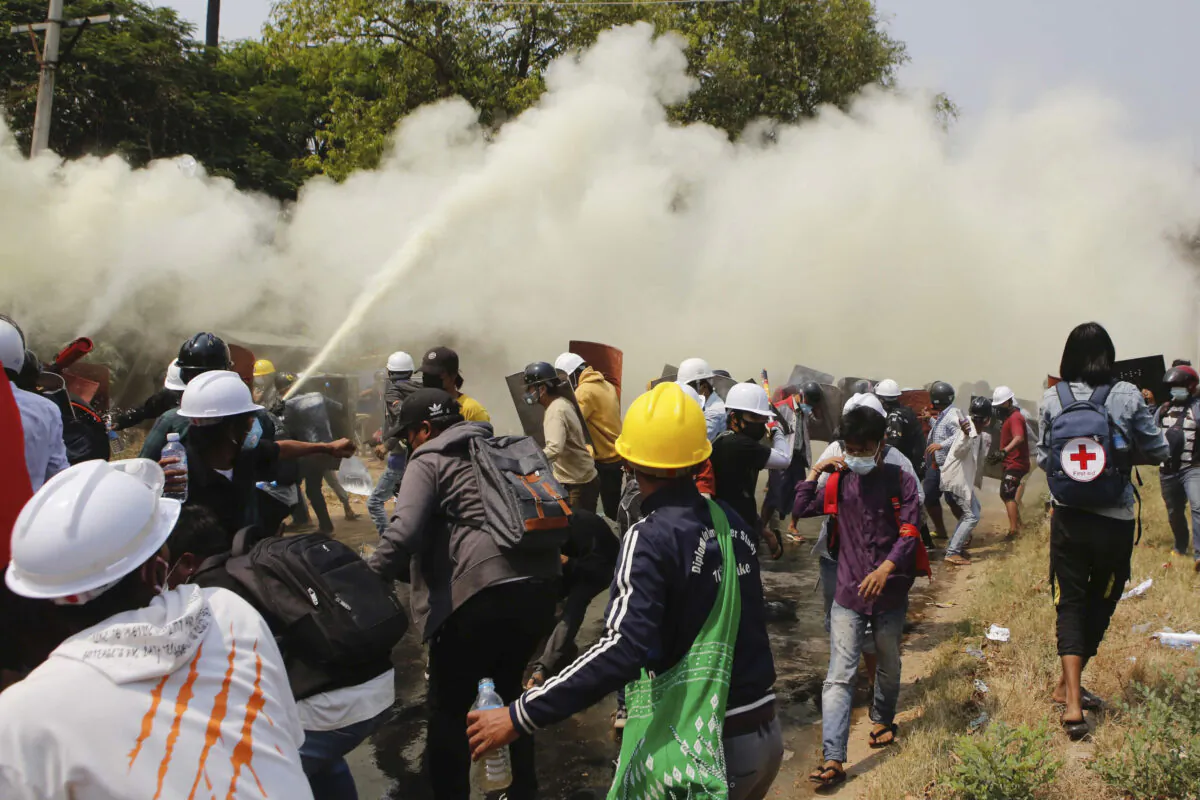 Anti-coup protesters discharge fire extinguishers to counter the impact of the tear gas fired by police during a demonstration in Naypyitaw, Burma, on March 8, 2021. (AP Photo)