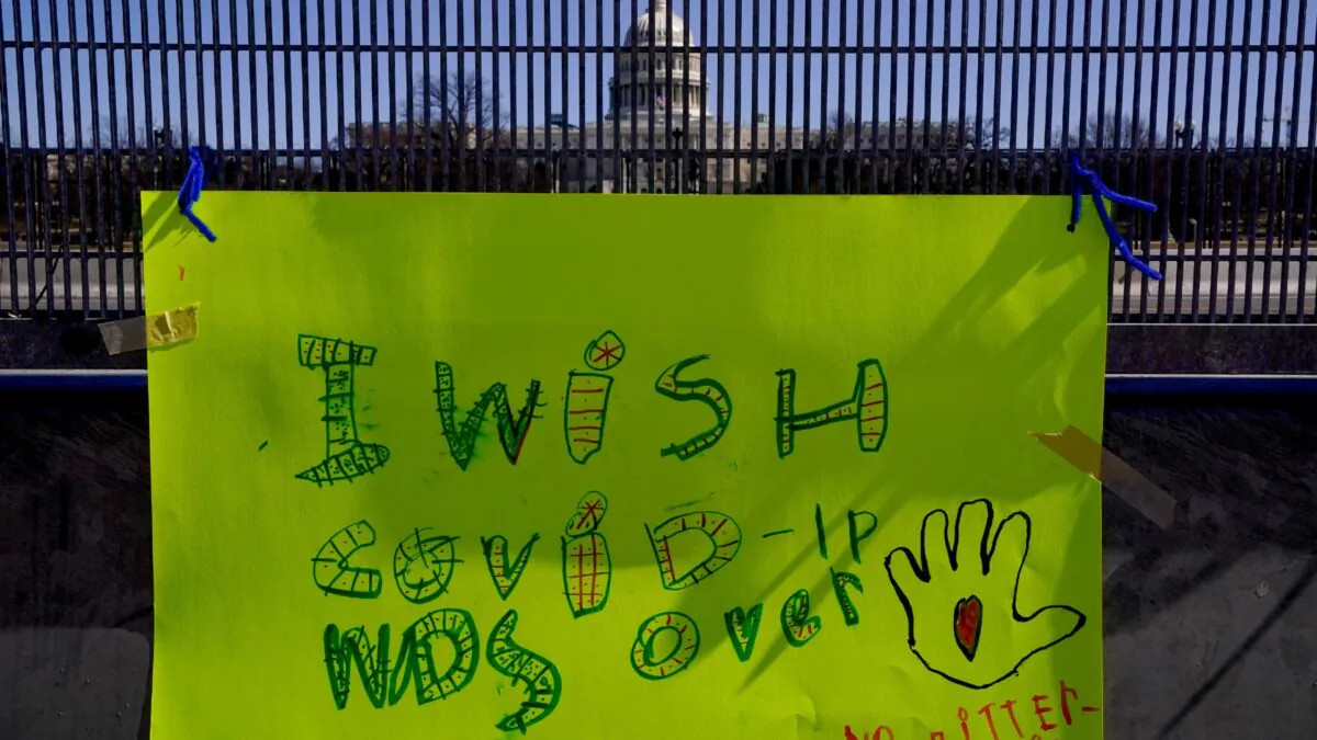 A sign reading, "I wish Covid-19 was over" is seen on security fence surrounding the U.S. Capitol in Washington, on March 7, 2021. (Erin Scott/Reuters)