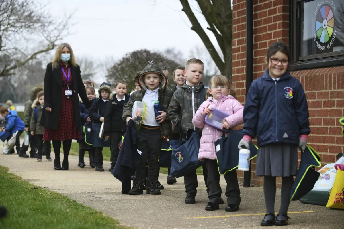 Children line up to enter a Primary Academy in Shipdham, England, on March 8, 2021. (Joe Giddens/PA via AP)