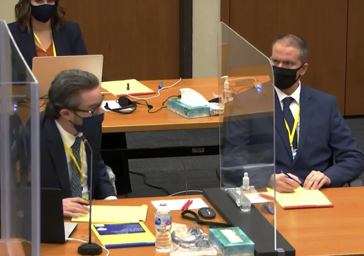 Defense attorney Eric Nelson (L) and defendant, former Minneapolis police officer Derek Chauvin (R) listen as Hennepin County Judge Peter Cahill presides over pretrial motions before jury selection at the Hennepin County Courthouse in Minneapolis, Minn., on March 8, 2021. (Court TV, via AP)