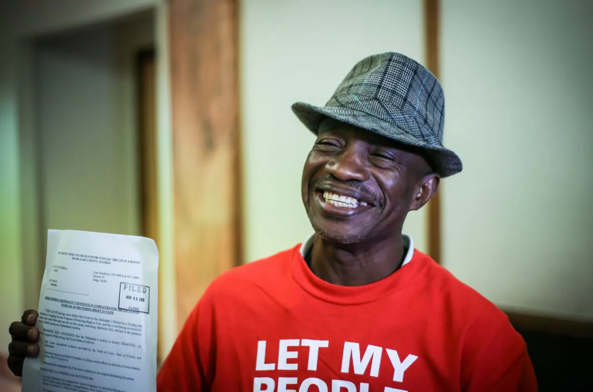 Leonel Frage, 60, who hasn't been able to vote in over 15 years due to a felony conviction, poses proudly holding a paper restoring his right to vote during a special court hearing aimed at restoring the right to vote under Florida's amendment 4 in a Miami-Dade County courtroom in Miami, Fla., on Nov. 8, 2019. (Zak Bennett/AFP via Getty Images)