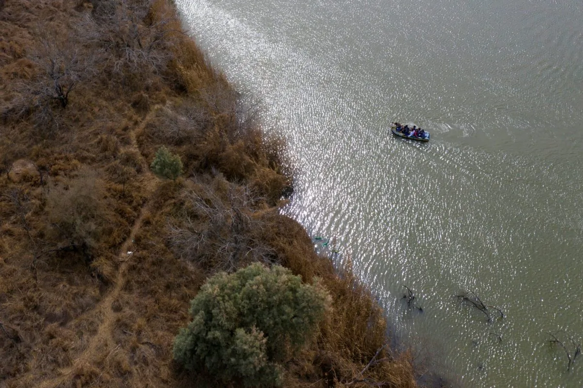 Smugglers use a raft to transport immigrant families and children across the Rio Grande River into the United States from Mexico in Penitas, Texas, on March 5, 2021. (Adrees Latif/Reuters)