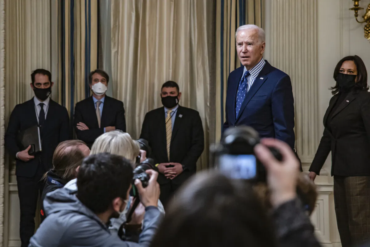 President Joe Biden stops to answer questions from reporters after speaking in the State Dining Room with Vice President Kamala Harris behind him following the passage of the American Rescue Plan in the U.S. Senate at the White House in Washington, on March 6, 2021. (Samuel Corum/Getty Images) 