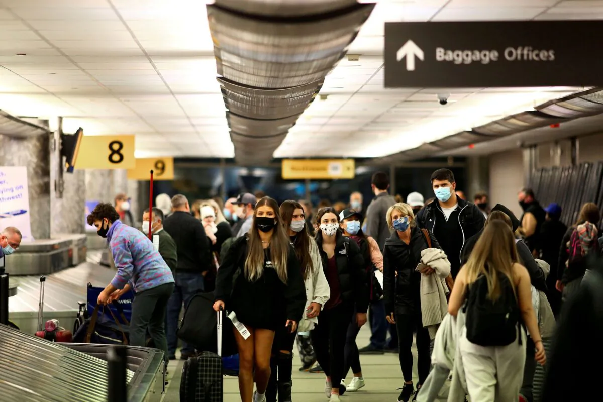 Travelers wearing protective masks reclaim their luggage at the airport in Denver, Colorado, on Nov. 24, 2020. (Kevin Mohatt/Reuters File Photo)
