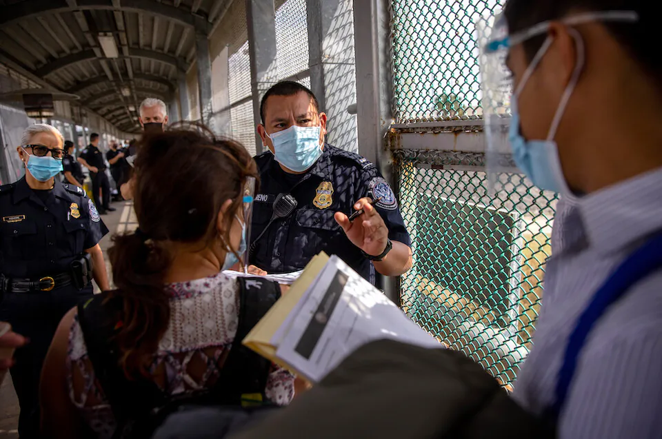 A Customs and Border Protection officer speaks with immigrants at the U.S.–Mexico border in Matamoros, Mexico, on Feb. 25, 2021. (John Moore/Getty Images)