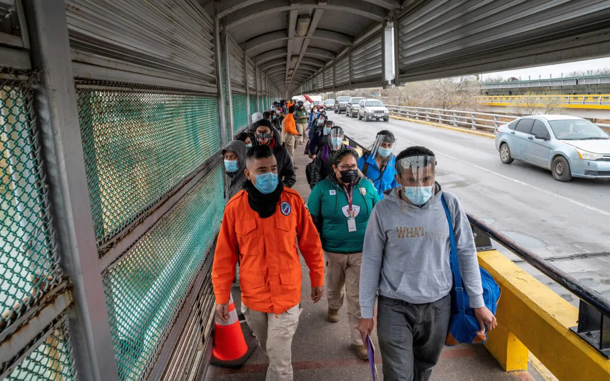 Migrants approach the U.S. border on Gateway International Bridge in Brownsville, Texas, on March 2, 2021. (Sergio Flores/AFP via Getty Images)