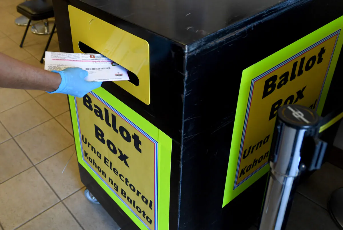 Clark County Election Department worker puts mail-in ballots collected from vehicles in a ballot box at the Clark County Election Department in North Las Vegas, Nev., on Oct. 13, 2020. (Ethan Miller/Getty Images)