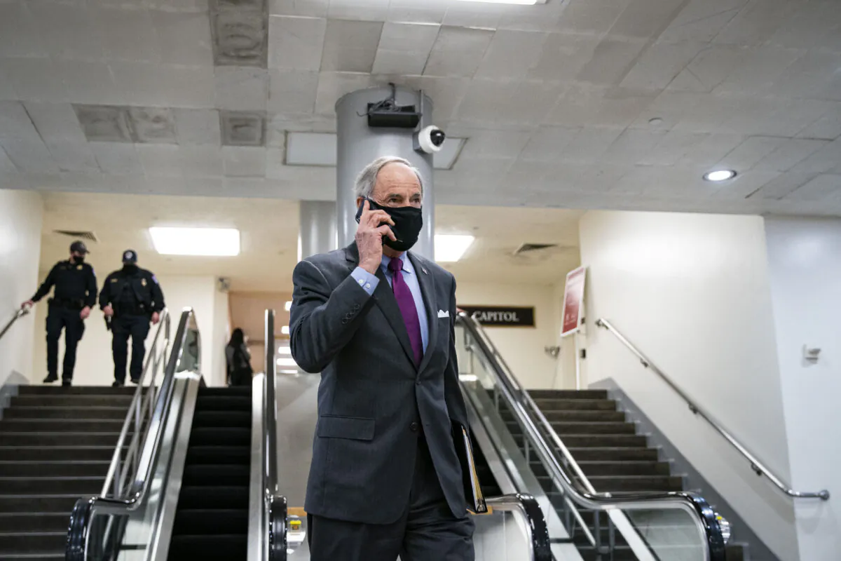 Sen. Tom Carper (D-Del.) speaks on a phone in Washington on Feb. 23, 2021. (Al Drago/Getty Images)