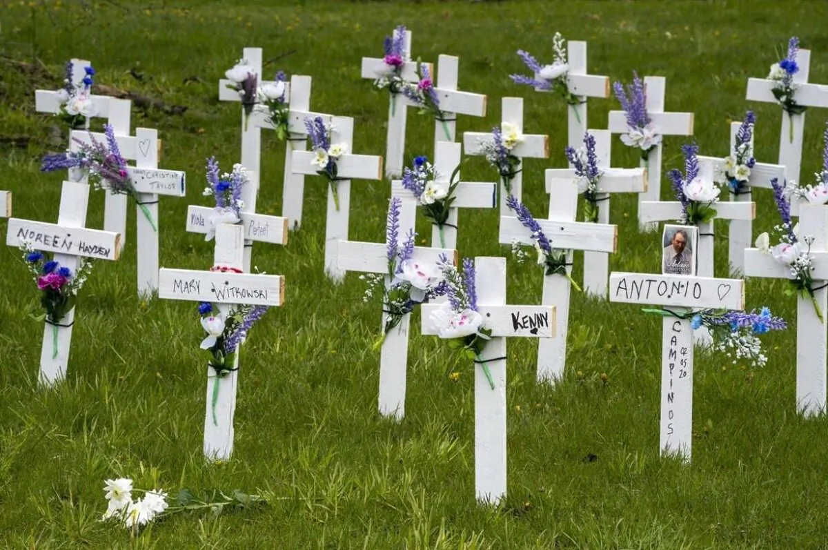 Flowers rest in front of crosses placed to remember the residents of Camilla Care Community who have lost their lives to COVID-19, in Mississauga, Ont. on May 11, 2020. Provisional estimates from Statistics Canada suggest nearly 14,000 more deaths than expected took place last year, even accounting for the pandemic and an aging population. (Frank Gunn/ The Canadian Press)