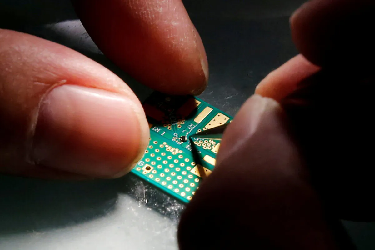 A researcher plants a semiconductor on an interface board during a research work to design and develop a semiconductor product at Tsinghua Unigroup research center in Beijing on Feb. 29, 2016.  (Kim Kyung-Hoon/Reuters)