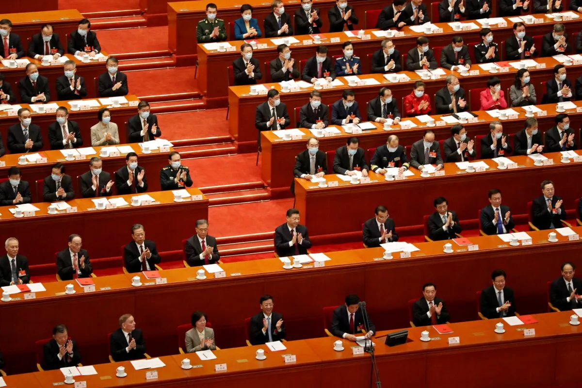 Chinese Communist Party leader Xi Jinping and other leaders applaud at the closing session of the National People's Congress (NPC) in Beijing on March 11, 2021. (Carlos Garcia Rawlins/Reuters)
