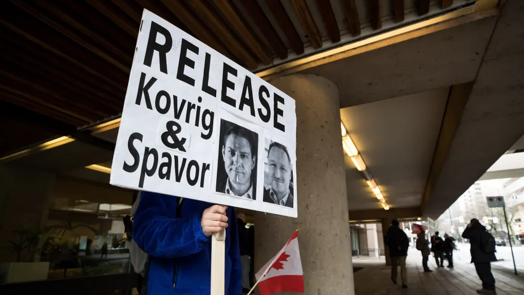 A man holds a sign calling for the release of Michael Kovrig and Michael Spavor outside B.C. Supreme Court where Huawei chief financial officer Meng Wanzhou was attending a hearing, in Vancouver on Jan. 21, 2020. (Darryl Dyck/The Canadian Press)