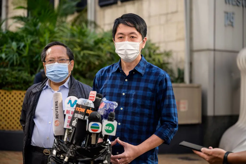Former lawmaker from Hong Kong's pro-democracy opposition Ted Hui (R), accompanied by veteran pro-democracy politician Albert Ho (L), speaks to the media as he leaves the Western Police Station in Hong Kong on November 18, 2020. (Anthony Wallace/AFP via Getty Images)