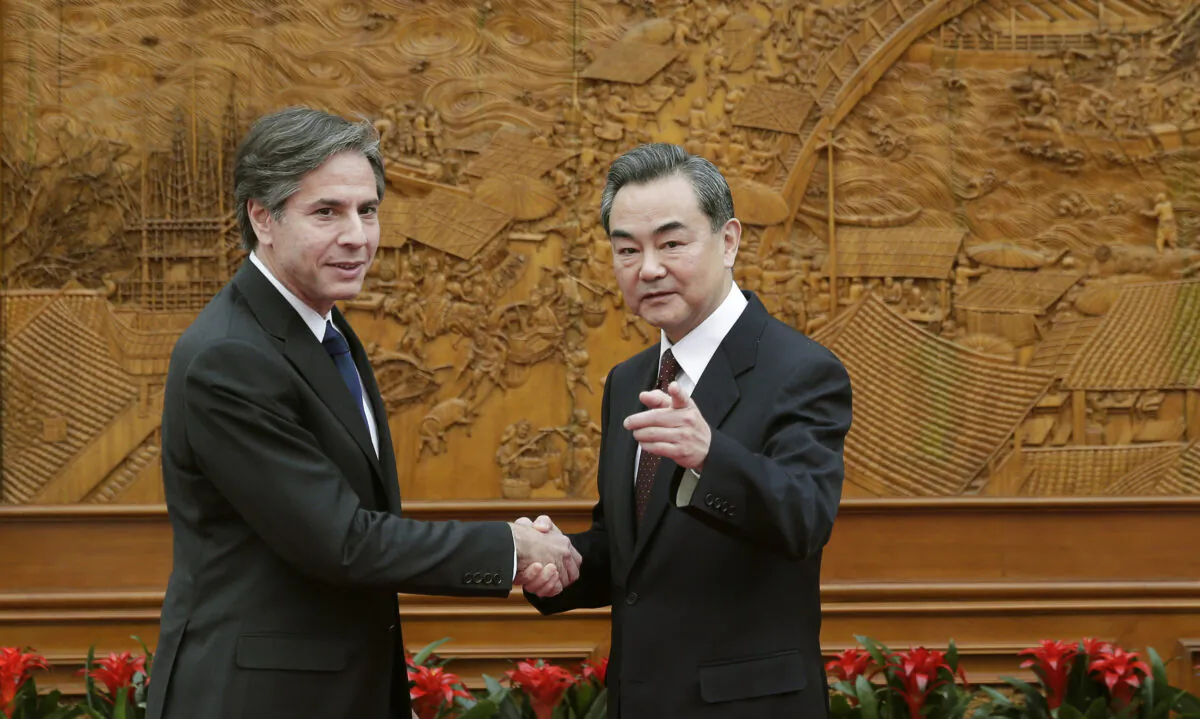 (L-R) Antony Blinken, who was then the U.S. Deputy Secretary of State, shakes hand with Chinese Foreign Minister Wang Yi at the Olive Hall in Beijing, China, on Feb. 11, 2015. (Andy Wong-Pool/Getty Images)