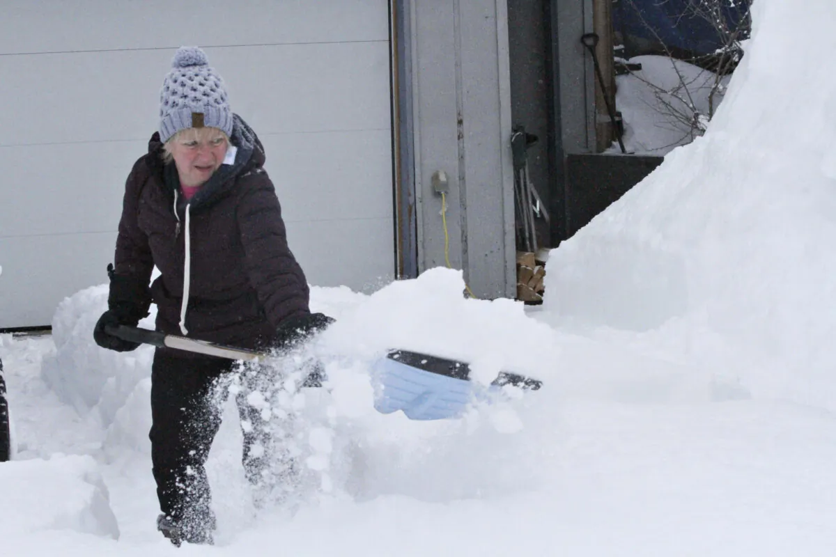Judi Westfall shovels snow at her home in Anchorage, Alaska, on March 11, 2021. (Mark Thiessen/AP Photo)