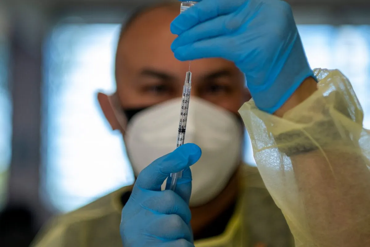 A health worker gives a shot of the Moderna vaccine at a Puerto Rico National Guard vaccination center during a priority COVID-19 vaccination program for the residents of the island of Vieques, Puerto Rico, on March 10, 2021. (Ricardo Arduengo/AFP via Getty Images)