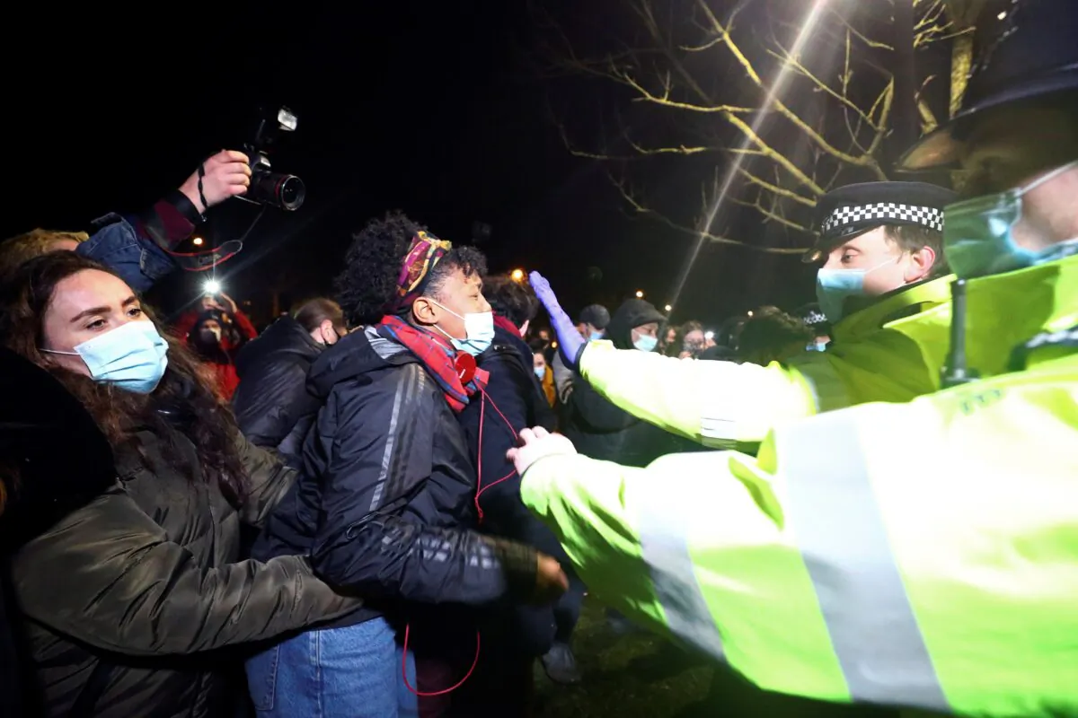 People clash with police during a gathering at a memorial site in Clapham Common Bandstand, following the alleged kidnap and murder of Sarah Everard, in London, on March 13, 2021. (Hannah McKay/Reuters)