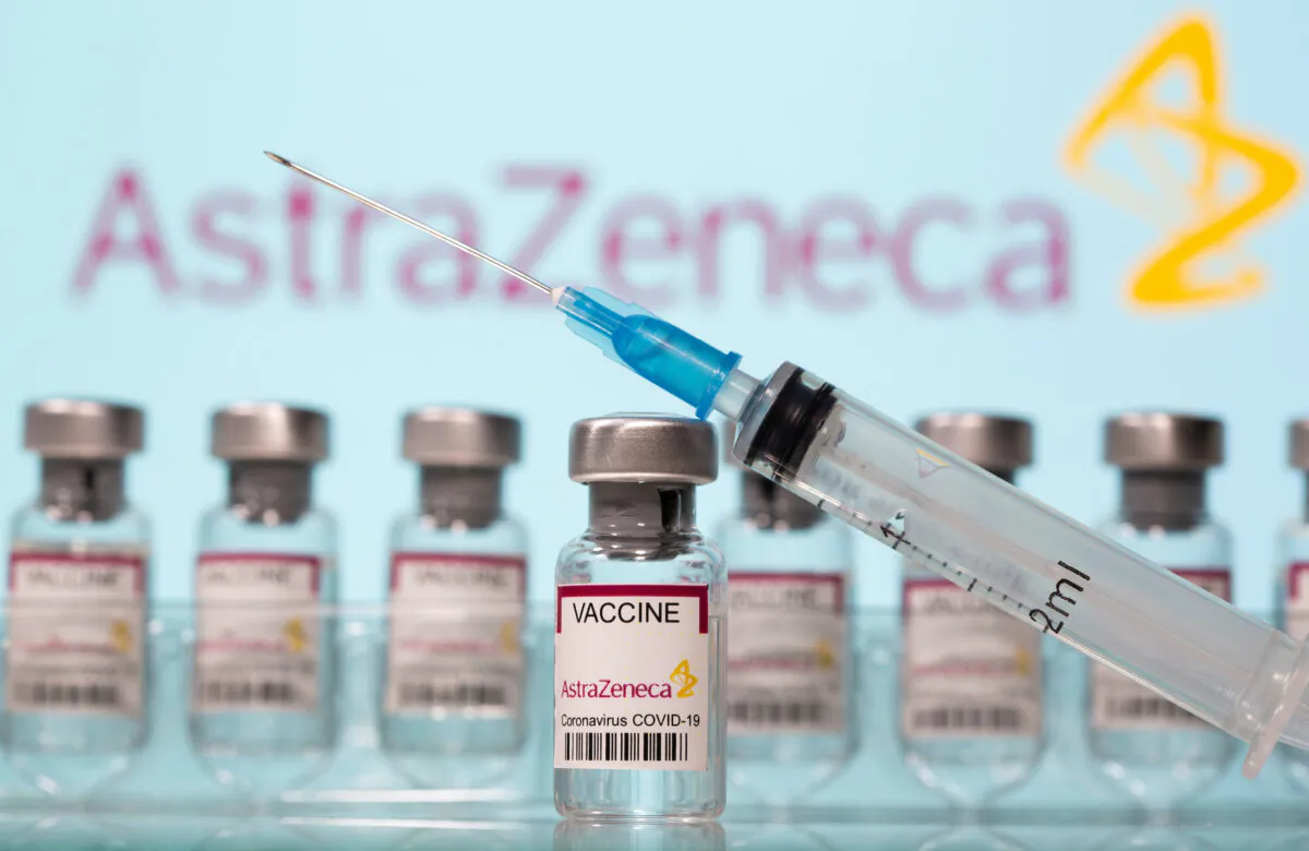 Vials labelled "AstraZeneca COVID-19 Vaccine" and a syringe are seen in front of a displayed AstraZeneca logo in this illustration taken on March 10, 2021. (Dado Ruvic/Illustration/ Reuters)