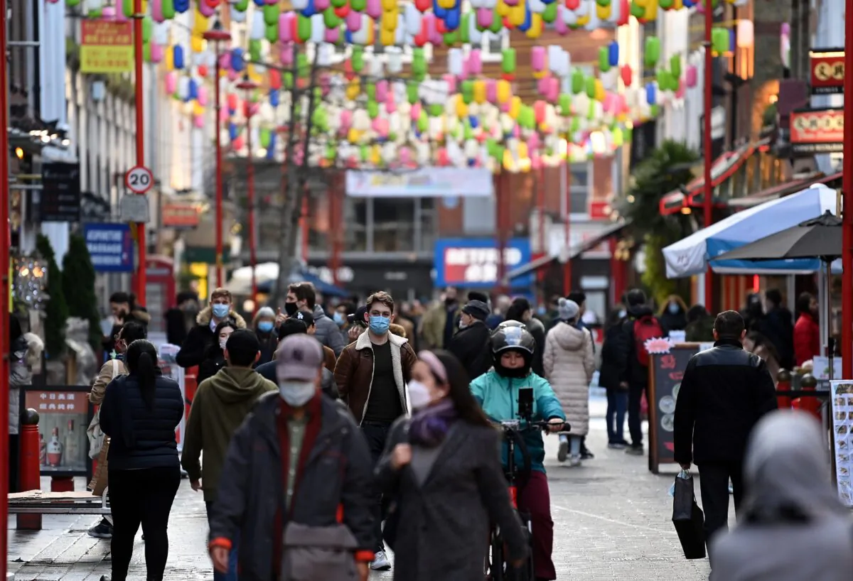 Pedestrians wearing face coverings due to the COVID-19 pandemic walk along a busy street in London on Dec. 15, 2020. (Daniel Leal-Olivas/AFP via Getty Images)