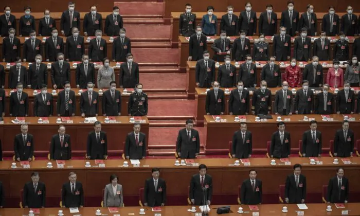 Chinese Communist Party’s head Xi Jinping (center) and lawmakers stand for the anthem during the closing session of the rubber-stamp legislature’s conference at the Great Hall of the People in Beijing, China, on March 11, 2021. (Kevin Frayer/Getty Images)