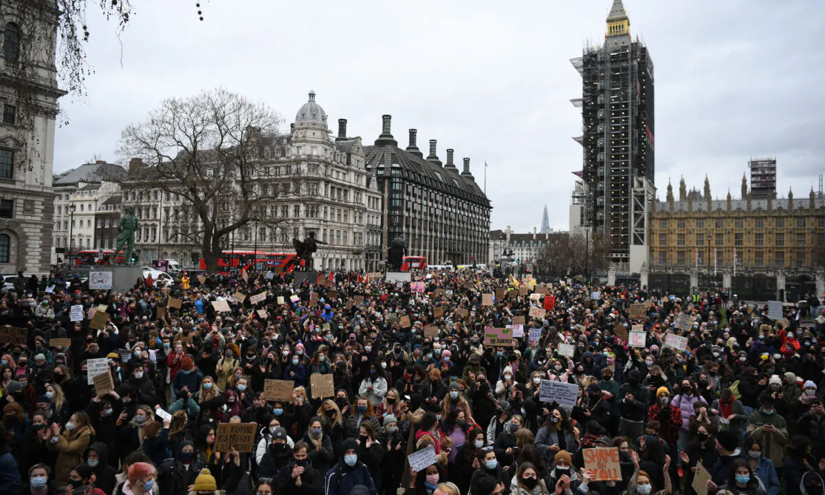 Protesters calling for greater public safety for women after the death of Sarah Everard, against the police handling of a gathering on Clapham Common in Sarah Everard's honour and against a proposed law that would give police more powers to intervene on protests hold placards as they gather in Parliament Square in central London on March 14, 2021. (Daniel Leal-Olivas/AFP via Getty Images)