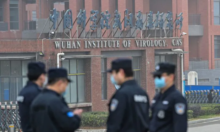 Security personnel stand guard outside the Wuhan Institute of Virology in Wuhan as members of the World Health Organization team investigating the origins of the CCP virus make a visit to the institute in Wuhan, China, on Feb. 3, 2021. (Hector Retamal /AFP via Getty Images)