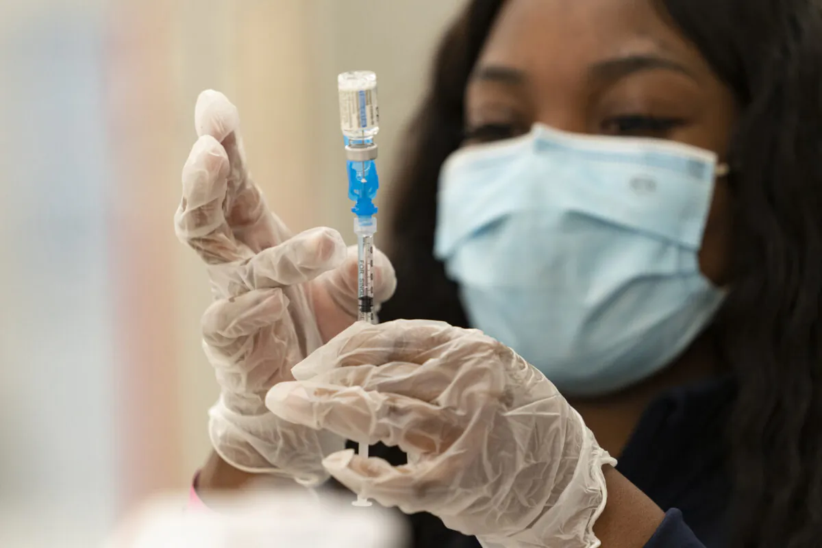 A health worker loads syringes with the vaccine on the first day of the Johnson & Johnson vaccine being made available to residents at the Baldwin Hills Crenshaw Plaza in Los Angeles, Calif., on March 11, 2021. (Damian Dovarganes/AP Photo)