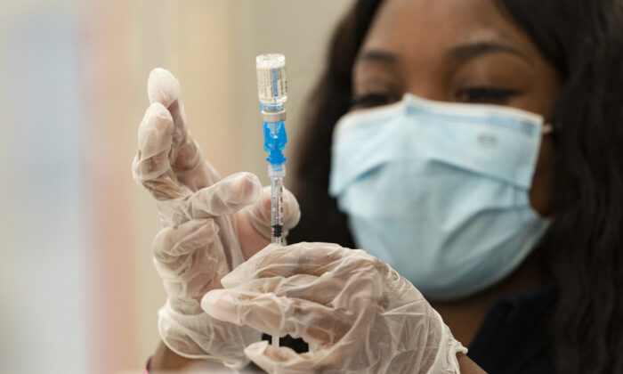 A health worker loads syringes with the vaccine on the first day of the Johnson & Johnson vaccine being made available to residents at the Baldwin Hills Crenshaw Plaza in Los Angeles on March 11, 2021. (Damian Dovarganes/AP Photo)