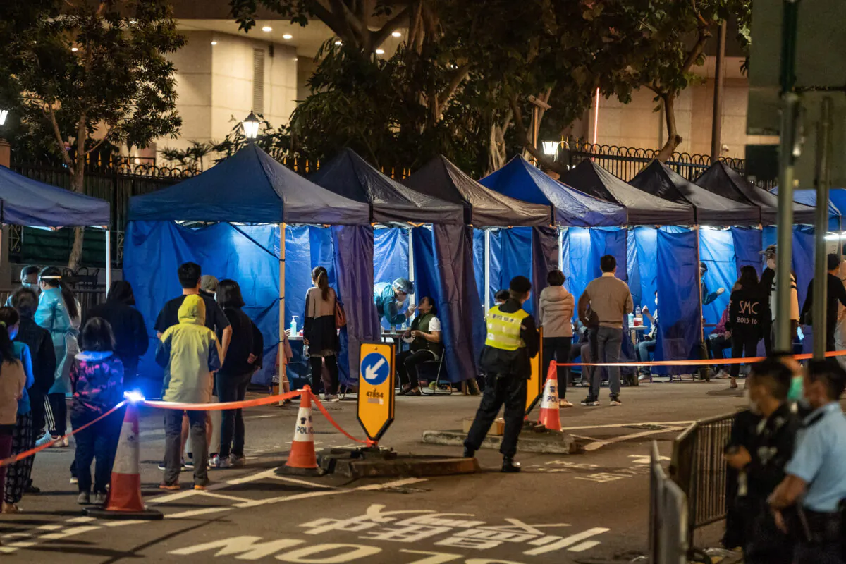 Residents receive mandatory COVID-19 test by health worker in an area under lockdown on Robinson Road at night in the mid-levels neighborhood in Hong Kong, China, on March 13, 2021. (Anthony Kwan/Getty Images)