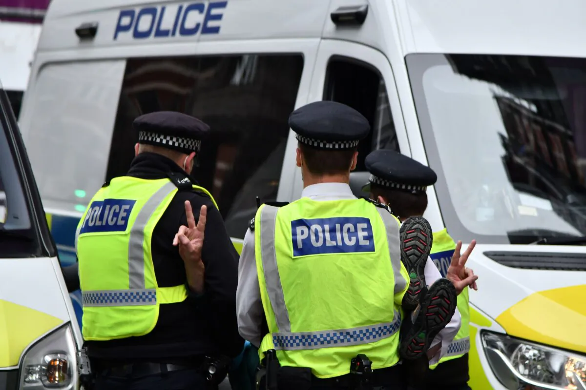 Police officers arrest an activist from the climate protest group Extinction Rebellion who was blocking the road protesting against animal farming outside the Department for Environment, Food, and Rural Affairs (DEFRA) in central London on Sept. 3, 2020. (Justin Tallis/AFP via Getty Images)