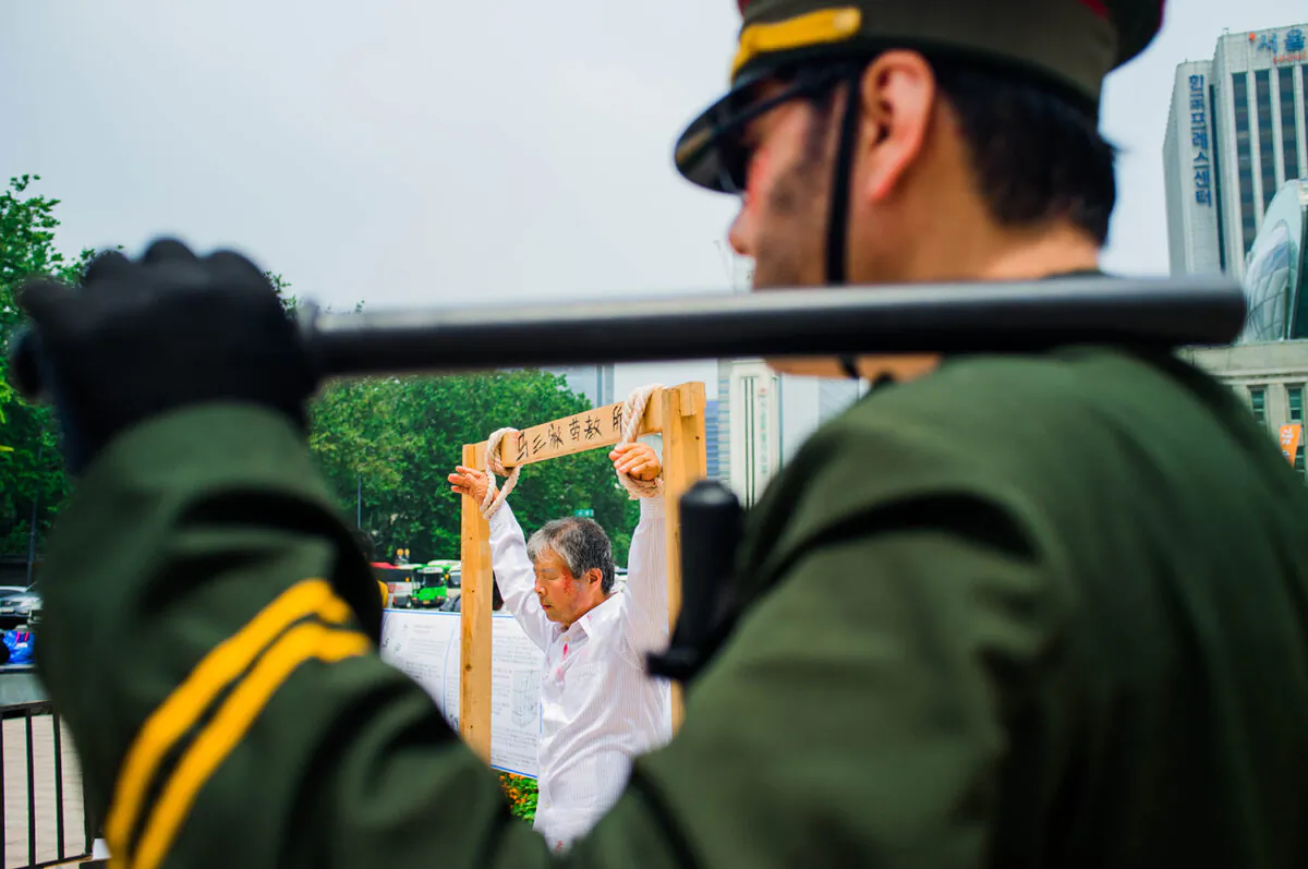 Protesters recreate human rights abuses taking place in Chinese prisons. (Jarrod Hall/The Epoch Times)
