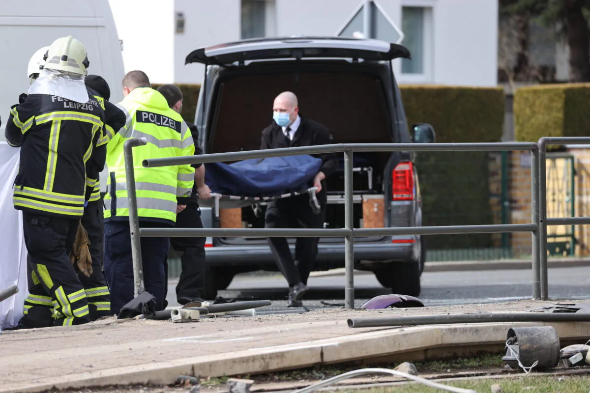 Employees of a funeral home carry a victim to a hearse in Leipzig, Germany, on March 16, 2021. (Jan Woitas/dpa via AP)