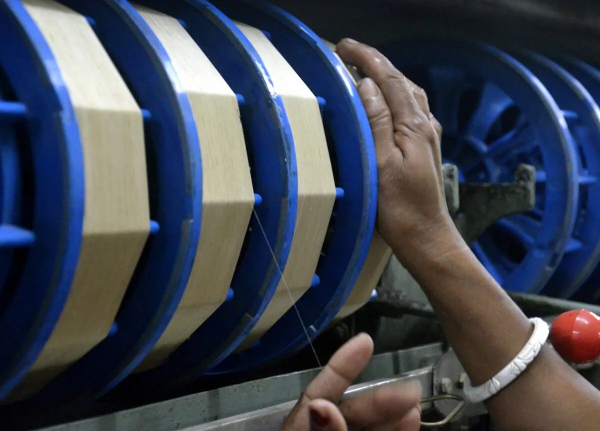 An Indian woman examining a thread of silk on a reel at a silk factory in Dharmanagar, in India's northeastern state of Tripura, on June 6, 2017.(Lovely Ghosh/AFP via Getty Images)