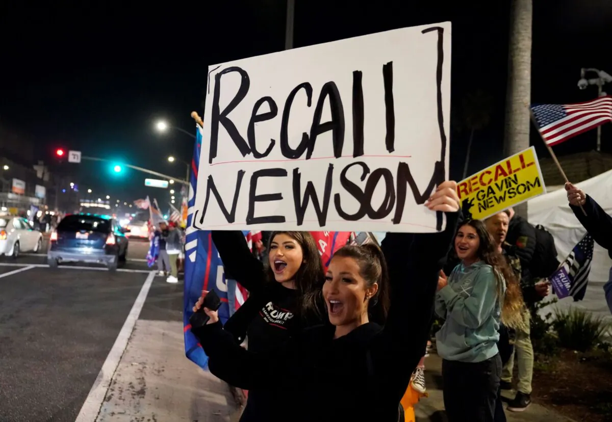 Demonstrators shout slogans while carrying a sign calling for a recall on California Gov. Gavin Newsom during a protest against a stay-at-home order amid the COVID-19 pandemic in Huntington Beach, Calif., on Nov. 21, 2020. (Marcio Jose Sanchez/AP Photo)