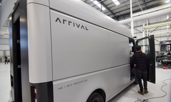 A man stands next to a fully-electric test van, due to go into production in 2022, built by electric van and bus maker Arrival Ltd, that has seen a spike in interest due to soaring e-commerce amid the coronavirus disease (COVID-19) pandemic and looming fossil-fuel vehicle bans, in Banbury, Britain, on Feb. 23, 2021. (Nick Carey/Reuters)