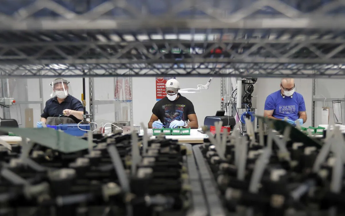 Ford Motor Co. line workers put together ventilators that the automaker is assembling at the Ford Rawsonville plant in Ypsilanti Township, Mich., on May 13, 2020. (Carlos Osorio/AP Photo)
