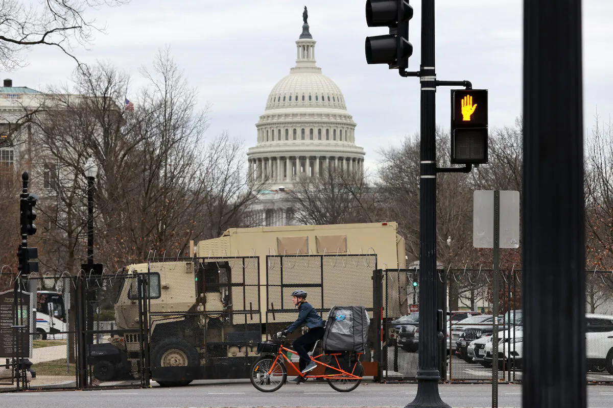 An eight-foot-tall security fence topped with concertina razor wire surrounds the U.S. Capitol and National Guard vehicles are parked inside the temporary perimeter in Washington, on March 16, 2021. (Chip Somodevilla/Getty Images)
