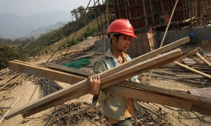 A Chinese worker carrying materials for a project of China's trillion-dollar Belt and Road Initiative in Laos on Feb. 8, 2020 (Aidan Jones/AFP via Getty Images)
