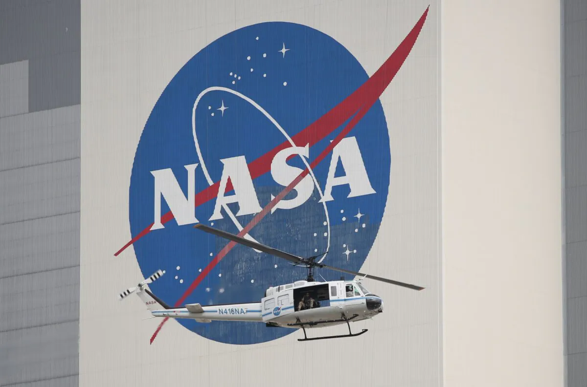 A NASA security helicopter flies past the Vehicle Assembly Building on launch day at the Kennedy Space Center in Florida on May 26, 2020. (GREGG NEWTON/AFP via Getty Images)