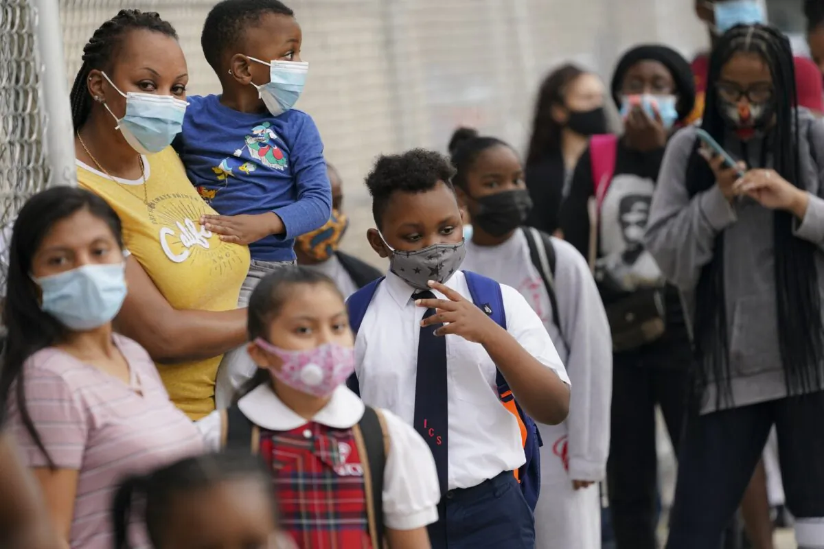 Students wear protective masks as they arrive for classes at the Immaculate Conception School while observing COVID-19 prevention protocols in The Bronx borough of New York on Sept. 9, 2020. (John Minchillo/AP Photo)