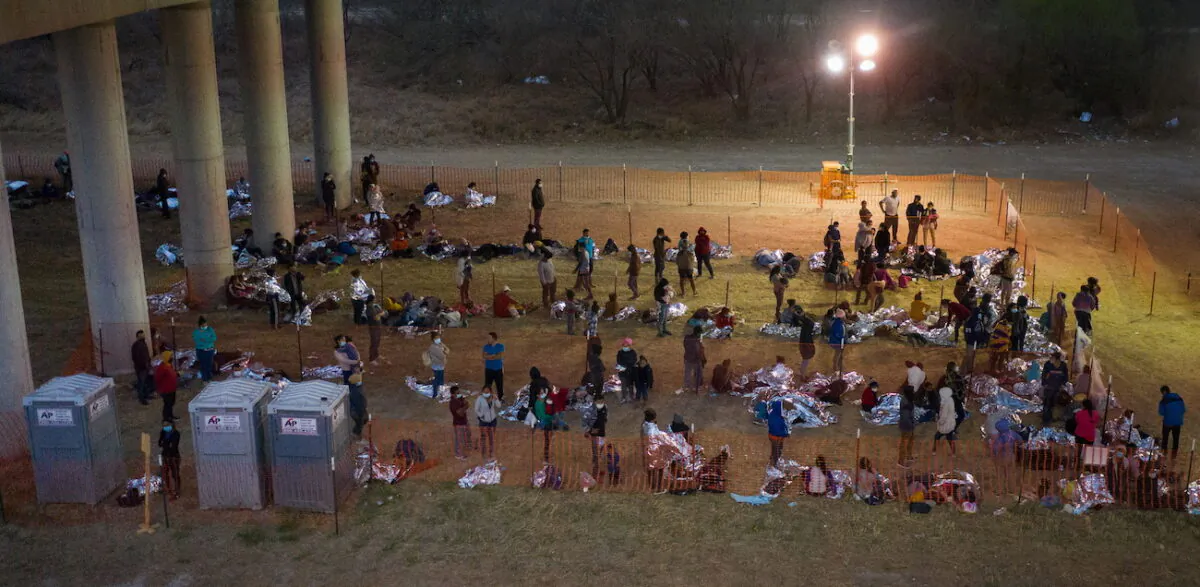 Illegal immigrants from Central America take refuge in a makeshift U.S. Customs and Border Protection processing center under the Anzalduas International Bridge after crossing the Rio Grande river into the United States from Mexico, in Granjeno, Texas, on March 12, 2021. (Adrees Latif/Reuters)