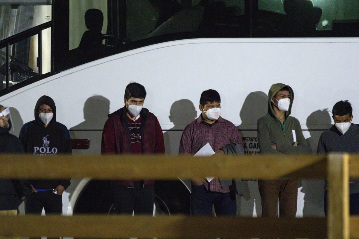 Children and teenagers who illegally crossed the U.S.-Mexico border wait to be processed after entering the site of a temporary holding facility south of Midland, Texas, on March 14, 2021. (Eli Hartman/Odessa American via AP)