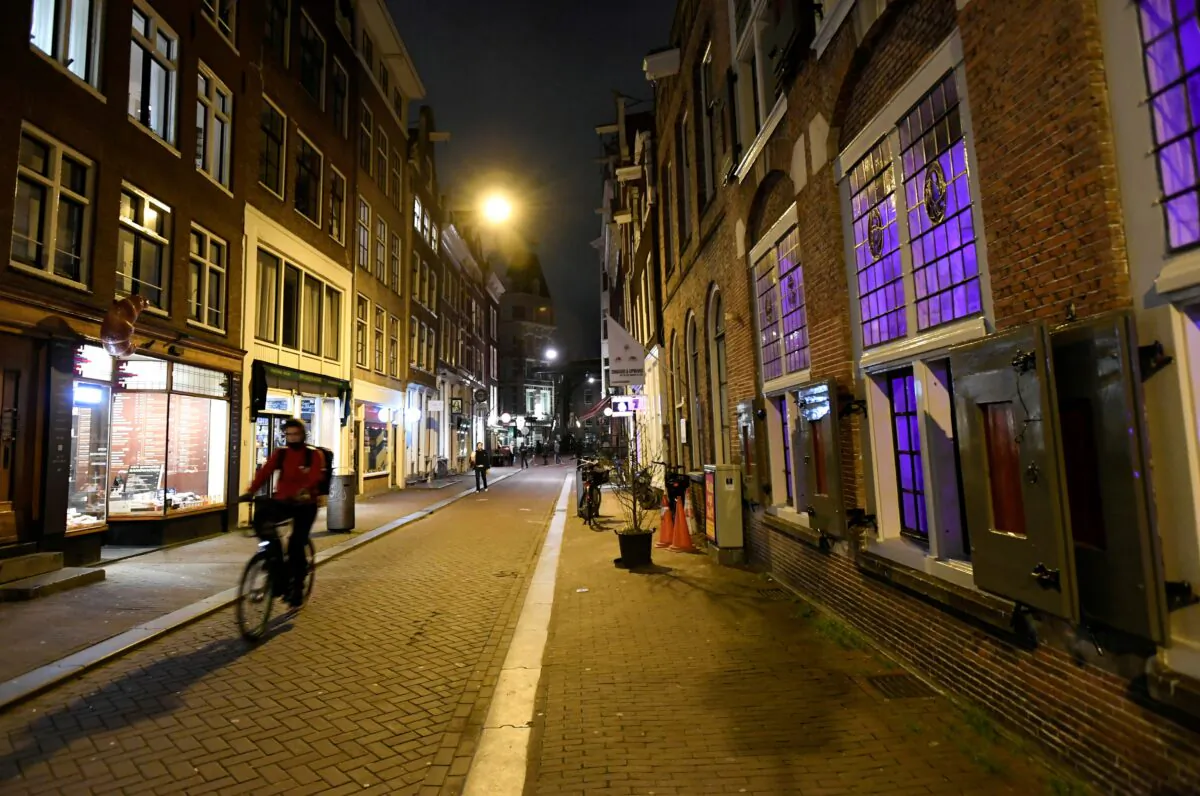 A cyclist drives down a street ahead of a curfew following the coronavirus disease (COVID-19) outbreak in Amsterdam, Netherlands, on Jan. 23, 2021. (Piroschka Van De Wouw/Reuters)